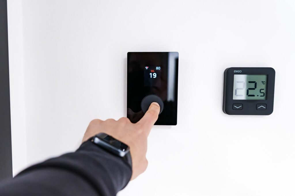 Hand adjusting a smart thermostat